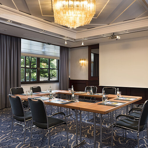 Sala de reuniones luminosa con tecnología moderna, grandes ventanas y lámpara elegante en Maritim Hotel Königswinter.