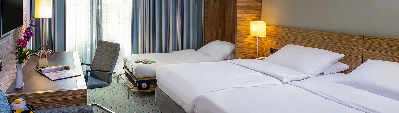 Camera familiare Comfort al Maritim Hotel Darmstadt con letto matrimoniale, letto aggiuntivo e area lavoro moderna
