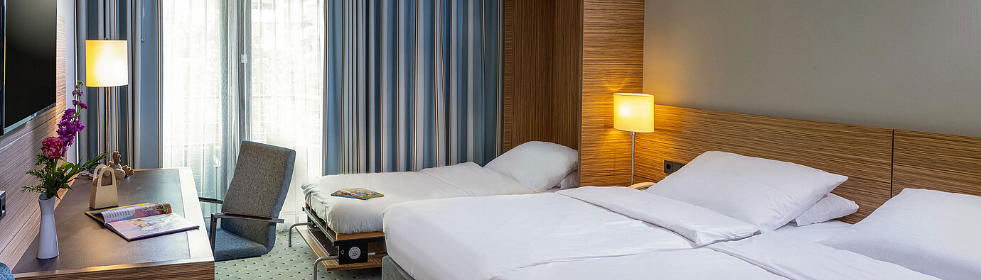 Comfort Family room at the Maritim Hotel Darmstadt with a double bed, extra bed, and modern workspace