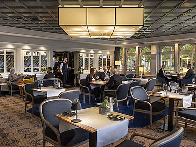  Restaurant élégant où les clients peuvent dîner et se détendre. Mobilier moderne et grandes fenêtres avec vue.