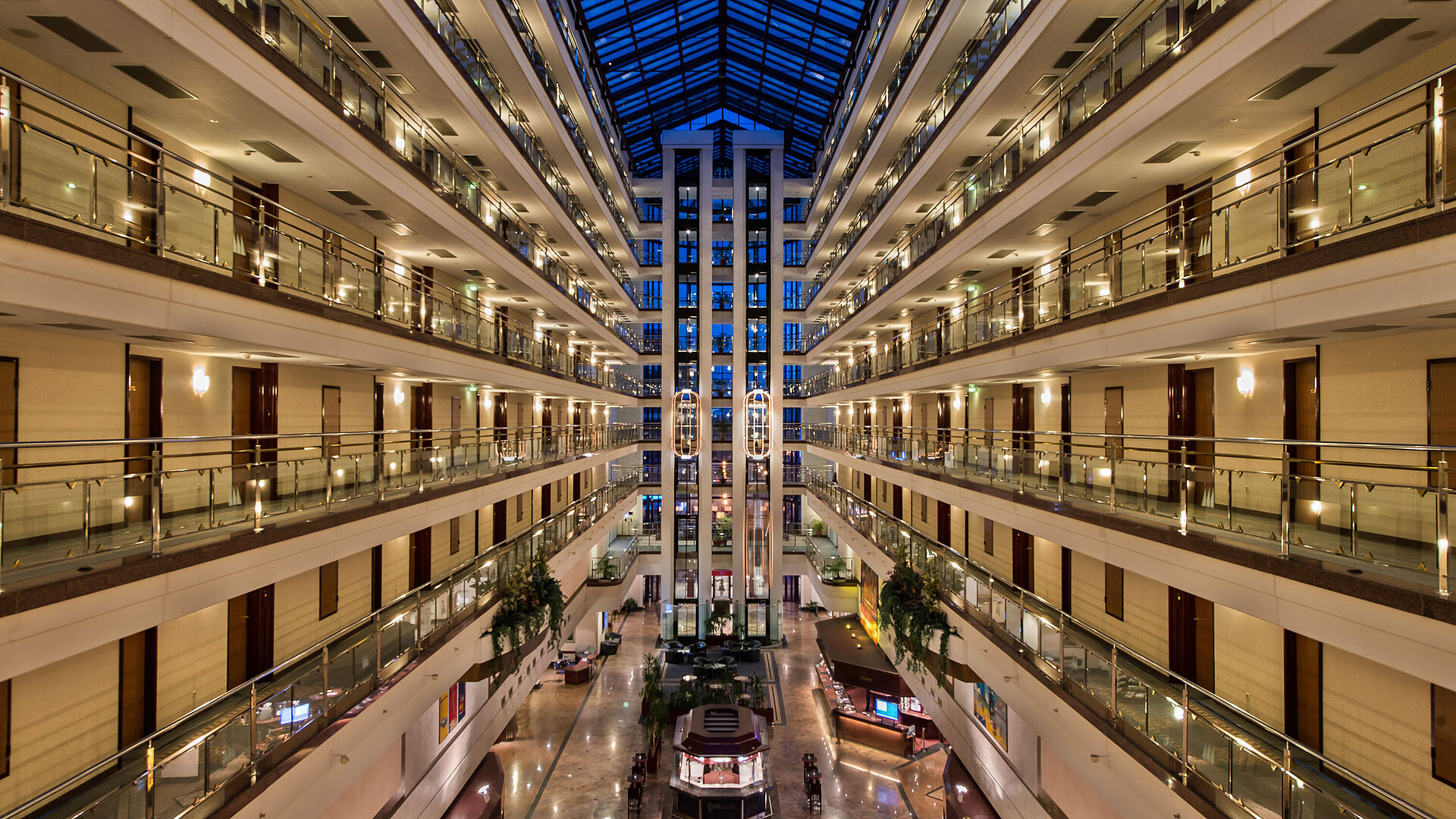 The spacious, bright lobby of Maritim Hotel with illuminated floors and modern architecture at night.