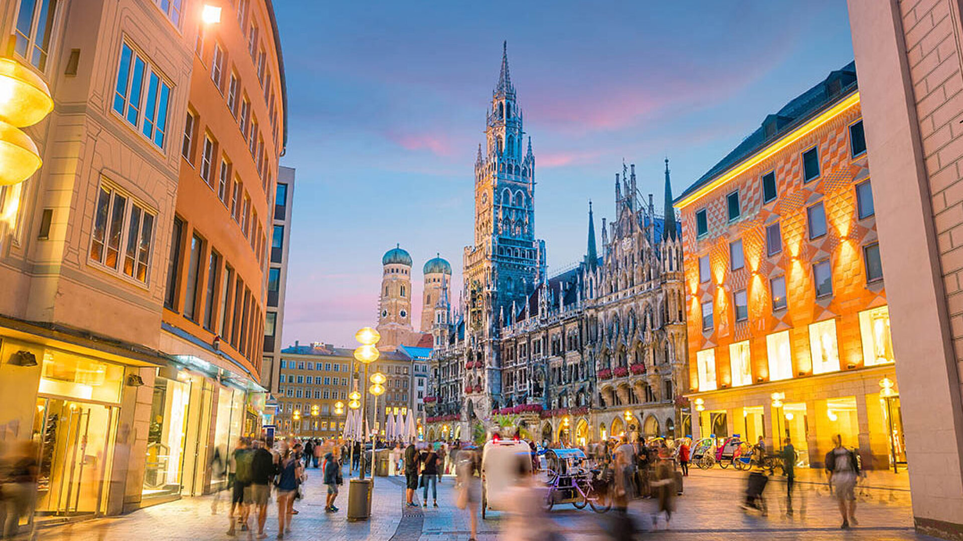 Marienplatz in Munich with New Town Hall, illuminated buildings and lively city centre in the evening