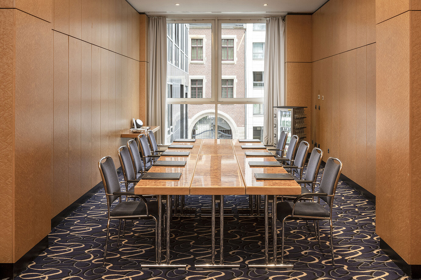 Sala de conferencias elegante en Maritim proArte Hotel Berlín con mesa y sillas en un entorno moderno.