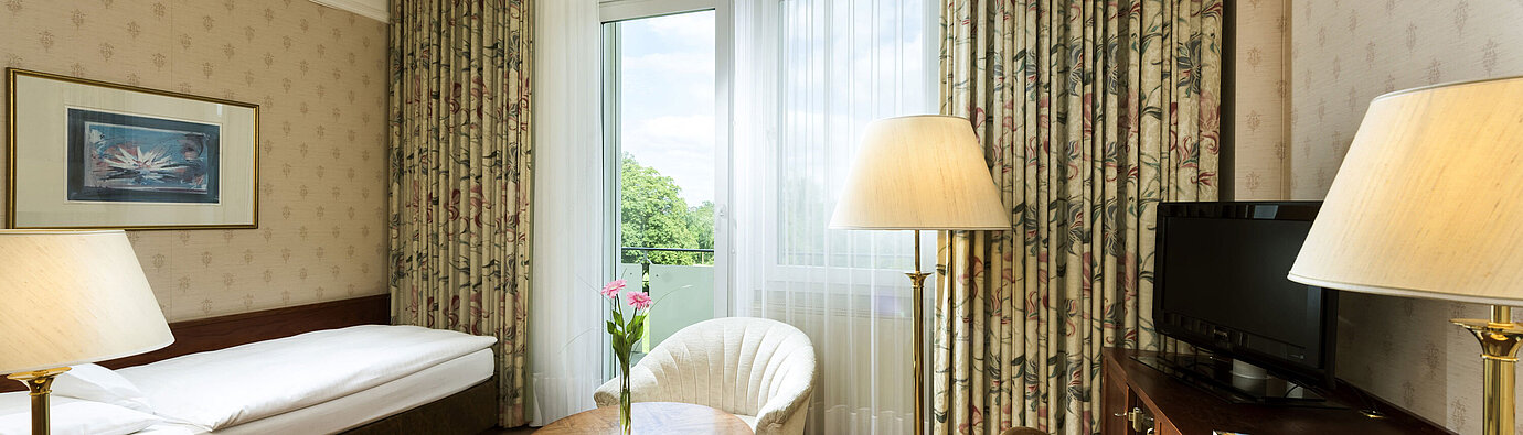 Habitación individual con balcón y vista verde en el Maritim Hotel Bad Wildungen