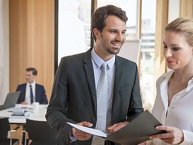 Business professionals discussing documents during a meeting at a hotel.