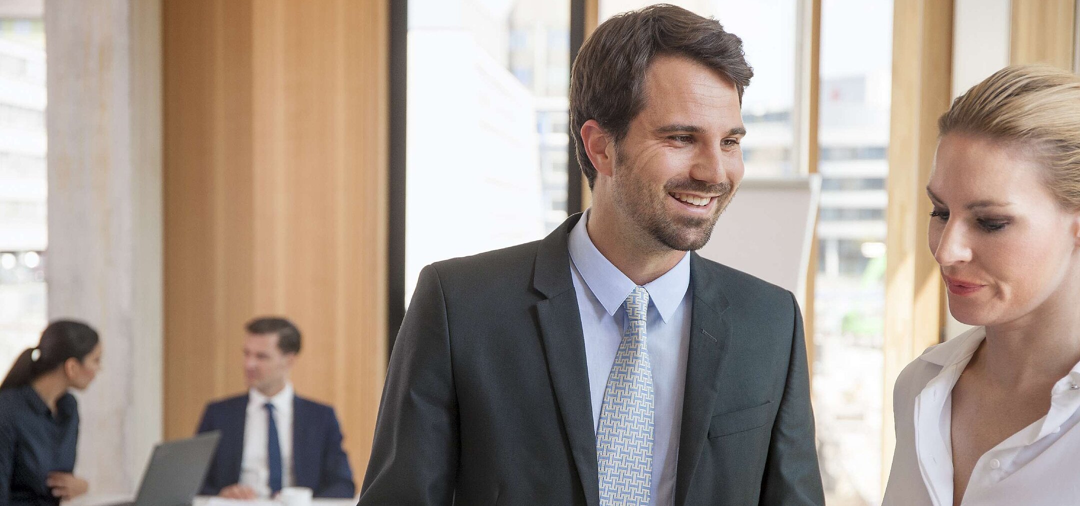 Business professionals discussing documents during a meeting at a hotel.