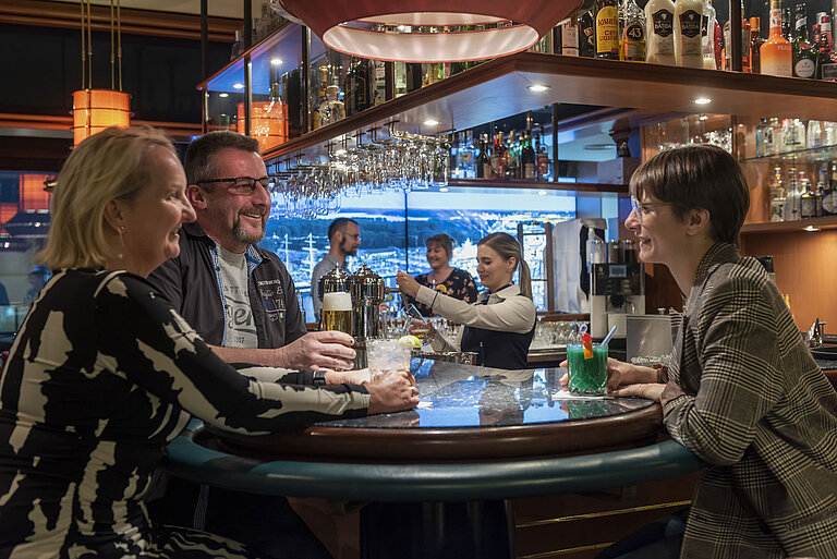 Guests chatting and enjoying drinks at the bar of Maritim Hotel Travemünde