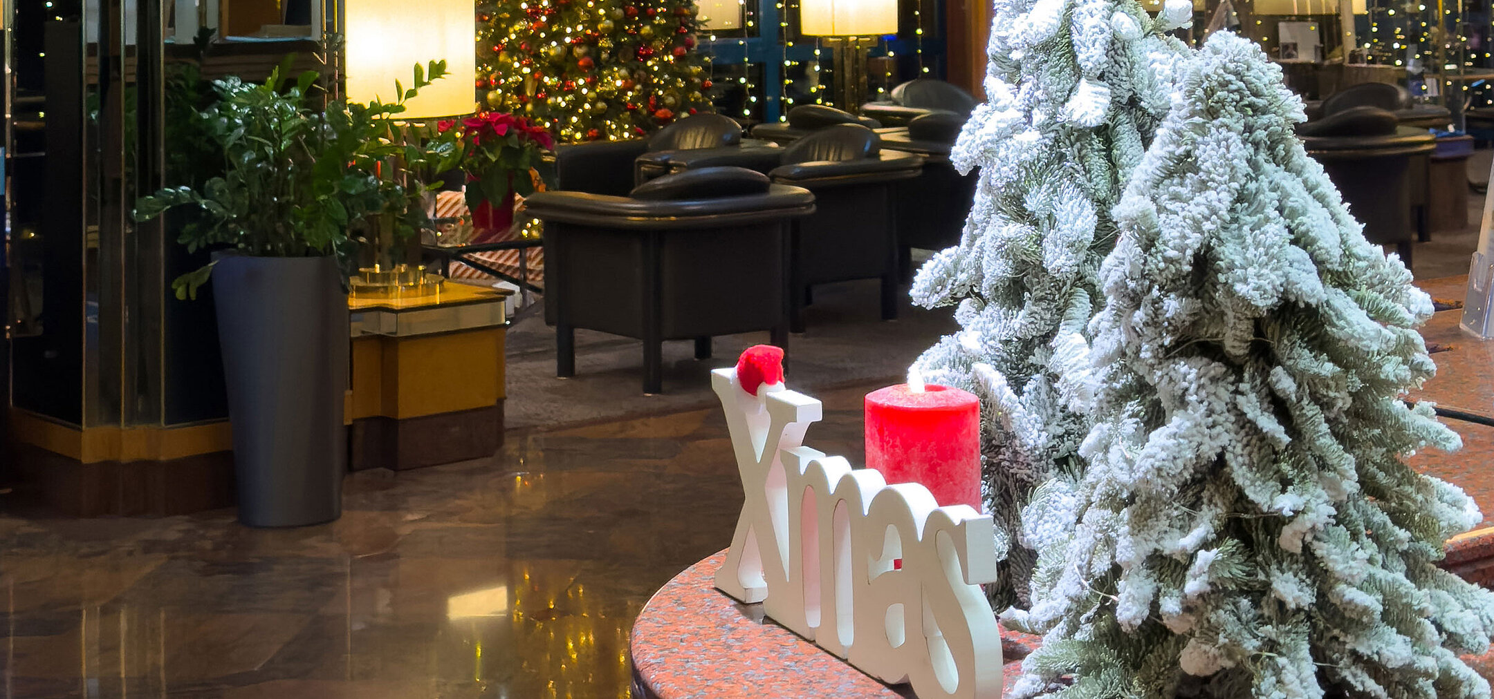 Festive hotel lobby with Christmas decorations Festively decorated hotel lobby with Christmas trees, chandelier and a warm winter atmosphere.