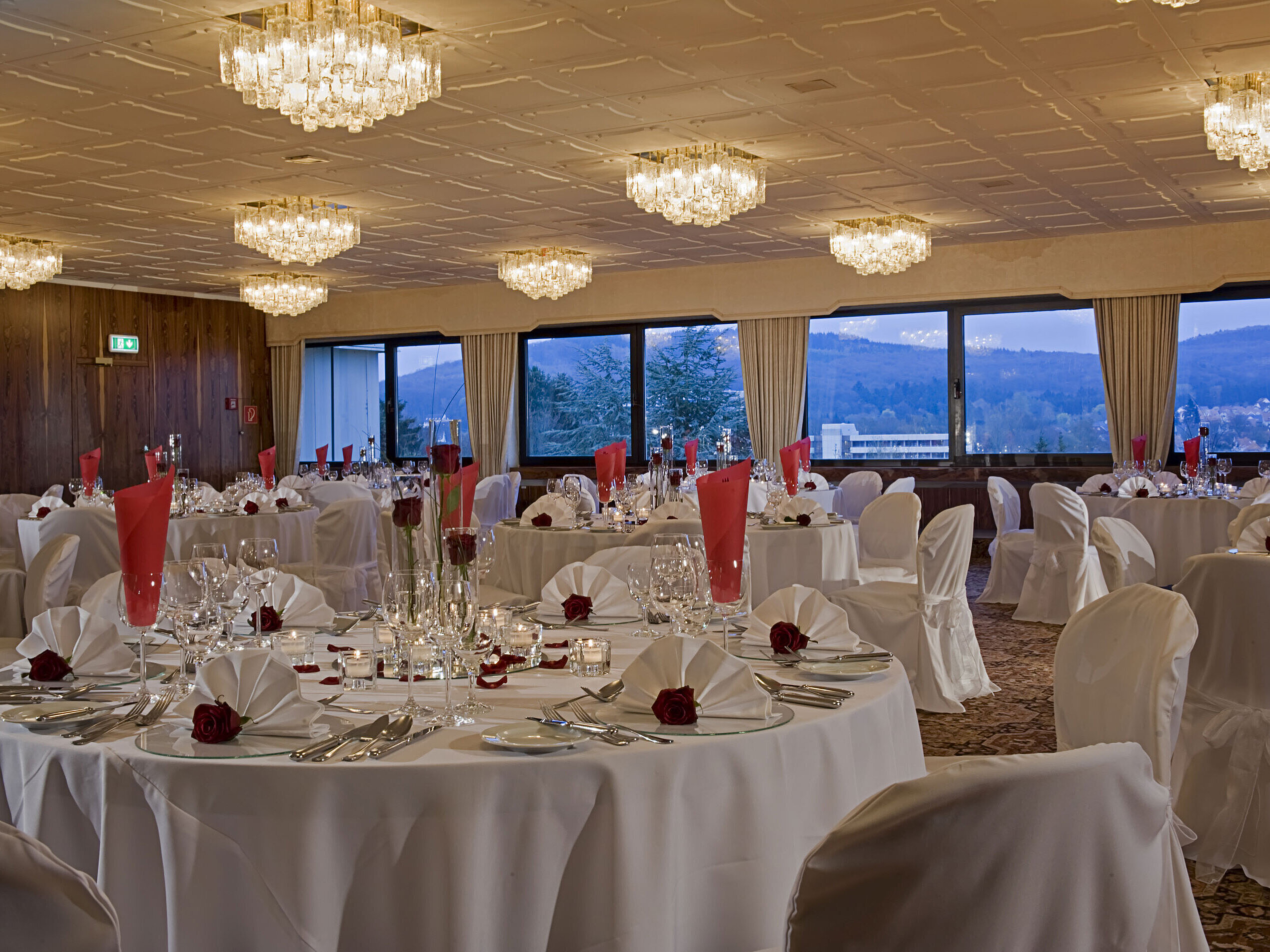 Amplio salón con mesas redondas y decoración elegante en Maritim Hotel Bad Salzuflen