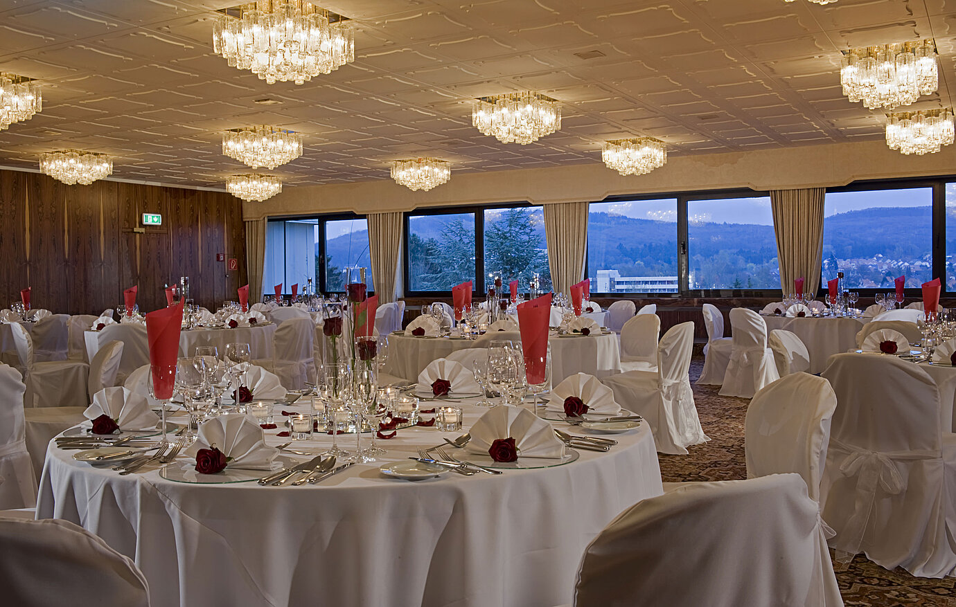 Amplio salón con mesas redondas y decoración elegante en Maritim Hotel Bad Salzuflen