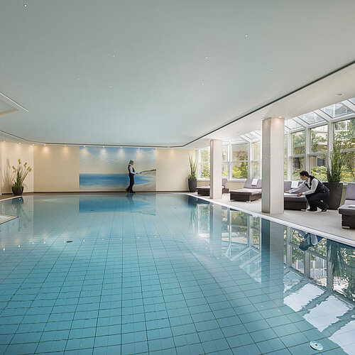 Grande piscine intérieure au Maritim Hotel Würzburg avec baie vitrée et service attentionné.