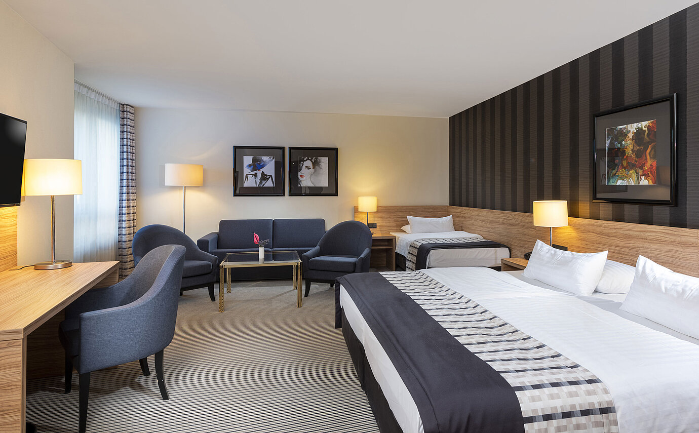 Chambre familiale confortable avec un design élégant et un coin salon cosy au Maritim Hotel Königswinter.