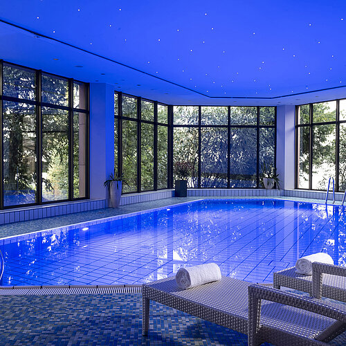 L’elegante piscina coperta del Maritim Hotel Bad Homburg offre un’atmosfera rilassante con luci soffuse e comodi lettini.