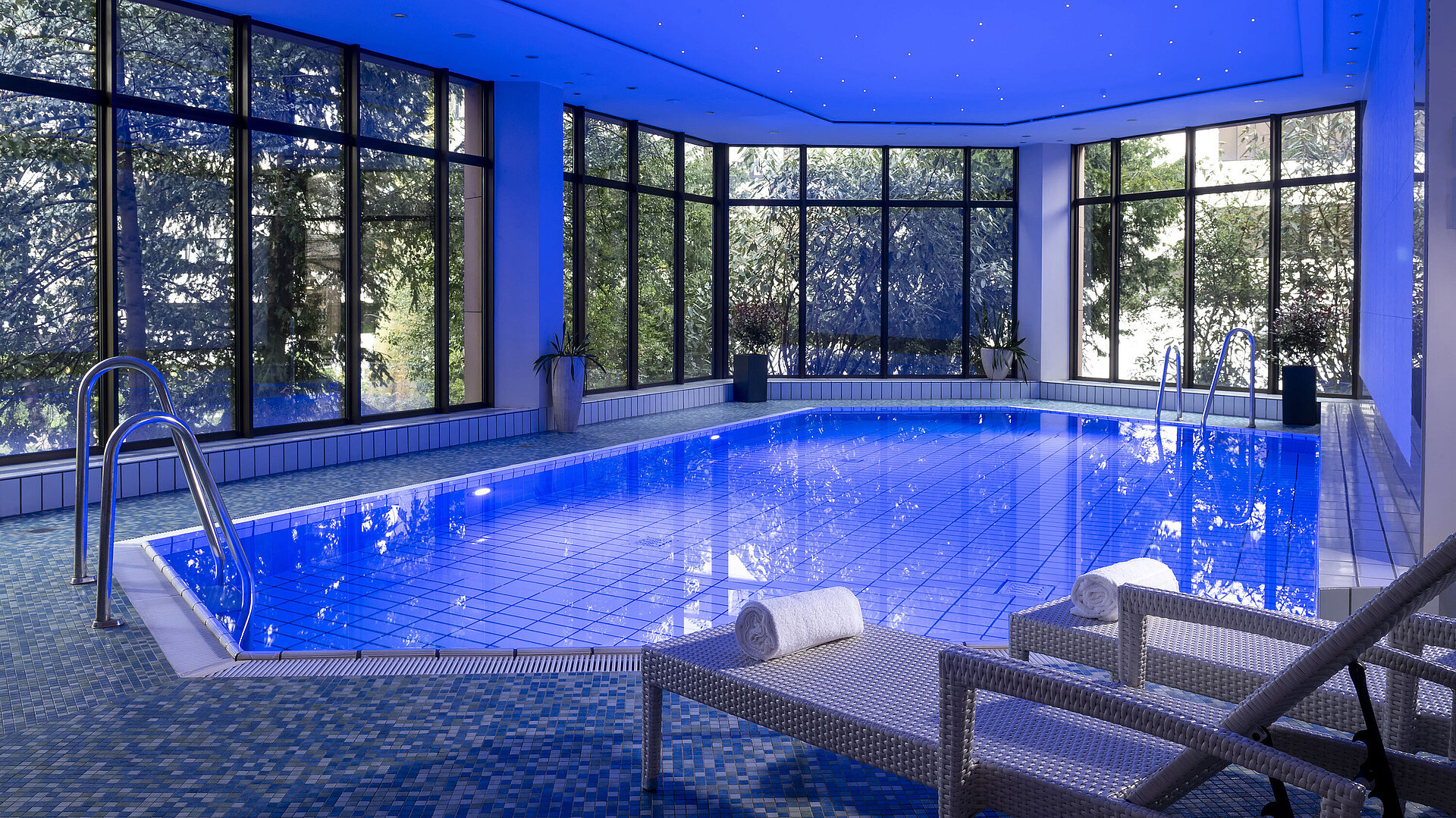 La piscine intérieure élégante du Maritim Hotel Bad Homburg invite à la détente avec une ambiance apaisante et des transats confortables.