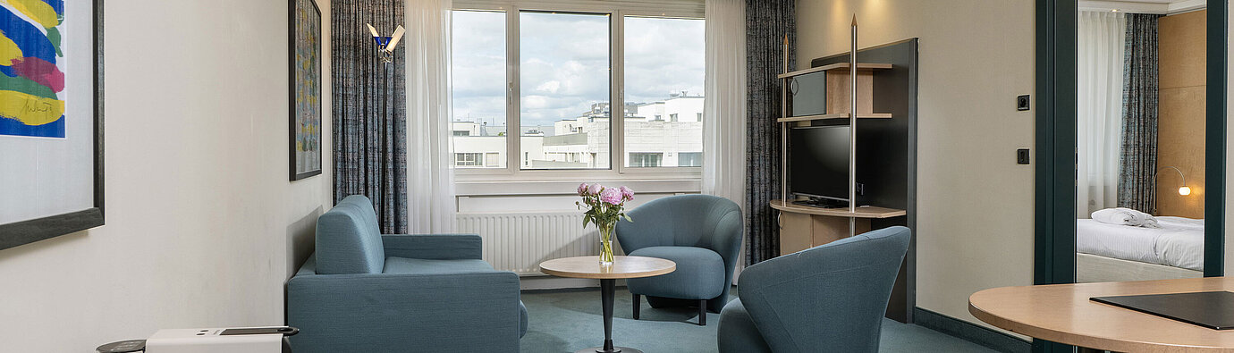 Bright suite with seating area, large window and coffee machine at Maritim proArte Hotel Berlin