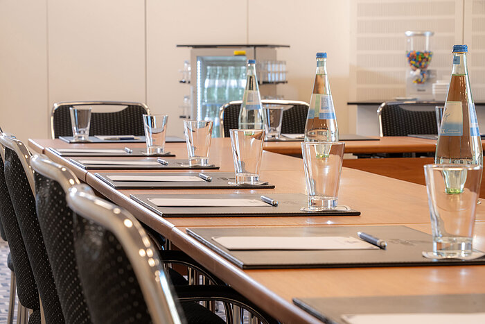 Table de conférence préparée au Maritim Hotel Bad Homburg avec eau et verres.