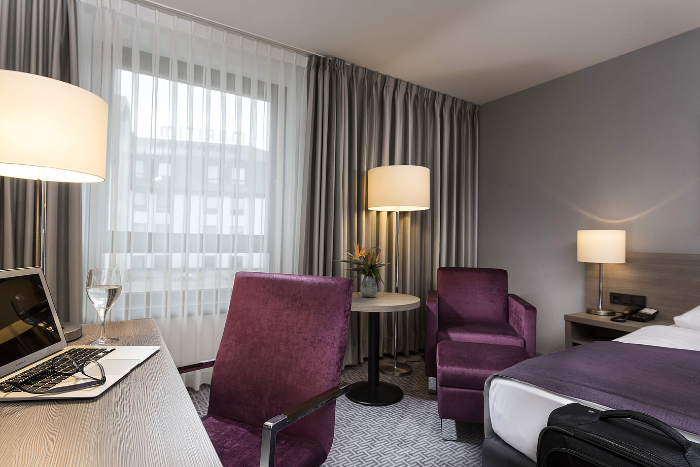 Chambre simple élégante de l'hôtel Maritim Königswinter avec bureau, fauteuil et design moderne.