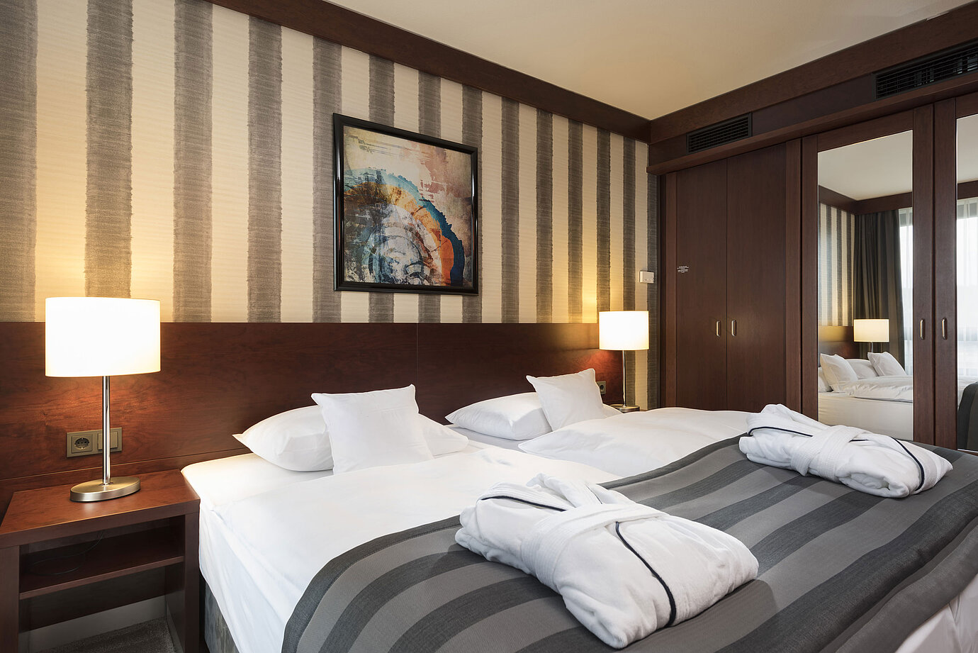Chambre double moderne avec lit douillet, peignoirs et intérieur élégant au Maritim Hotel Königswinter.