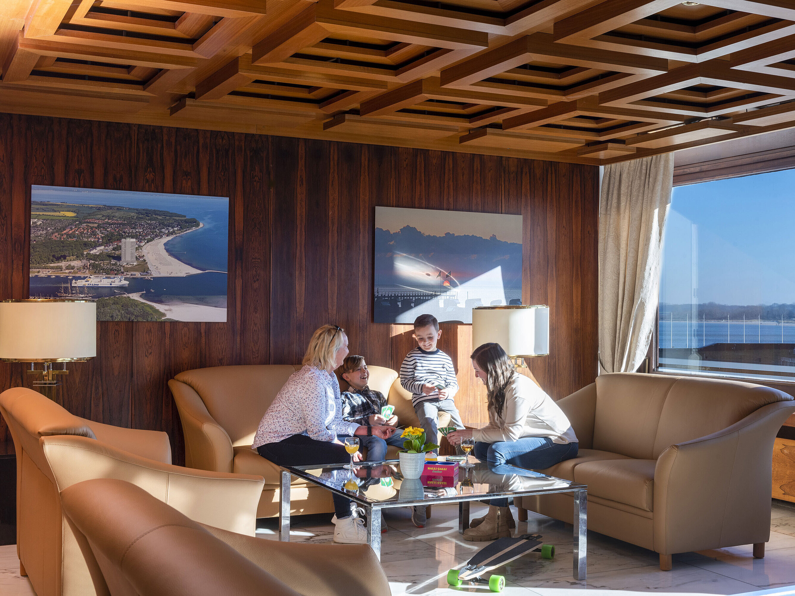 Due adulti e due bambini nella lounge con vista sul Mar Baltico al Maritim Hotel Travemünde