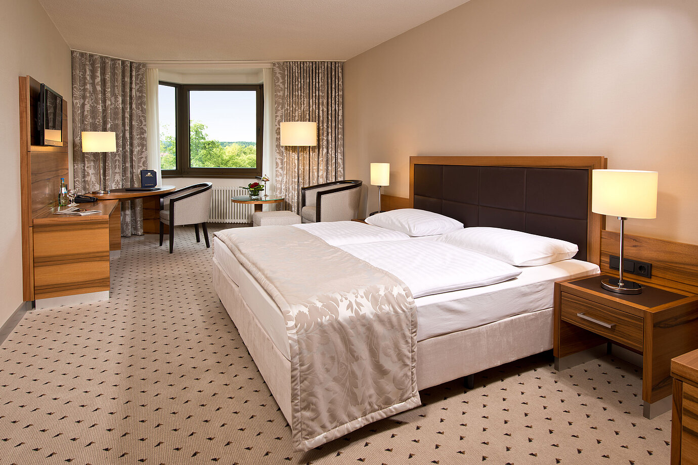 Habitación cómoda en el Hotel Maritim Bad Homburg con diseño moderno y vistas verde.