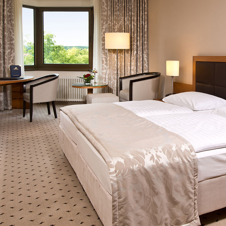 Chambre confortable à l'hôtel Maritim Bad Homburg avec design moderne et vue sur la verdure.