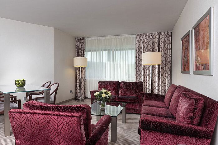 Suite familiare luminosa e spaziosa al Maritim Hotel Bonn con mobili moderni e area salotto accogliente.