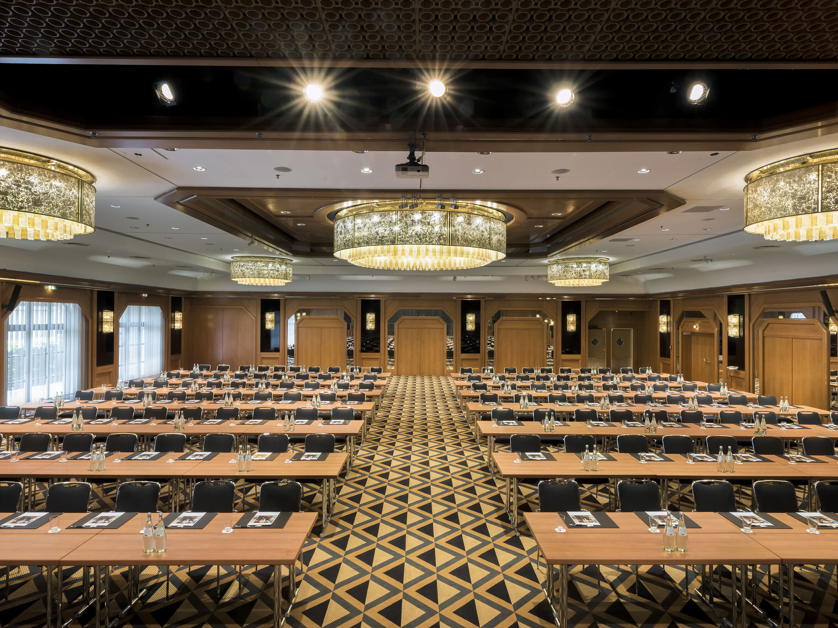 Sala de conferencias elegante con escenario, lámparas y asientos modernos en Maritim Hotel Königswinter.