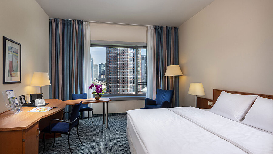 Chambre Supérieure du Maritim Hotel Frankfurt avec lit double, bureau et vue sur la skyline de Francfort.