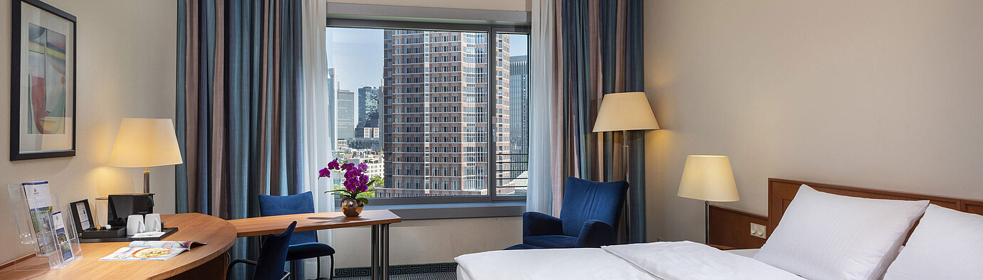 Chambre Supérieure du Maritim Hotel Frankfurt avec lit double, bureau et vue sur la skyline de Francfort.