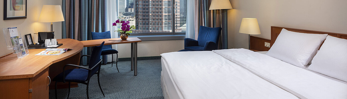 Chambre Supérieure du Maritim Hotel Frankfurt avec lit double, bureau et vue sur la skyline de Francfort.