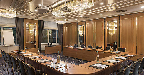 Sala en forma de U con sillas elegantes, proyectores y lámparas en el Maritim Hotel Stuttgart