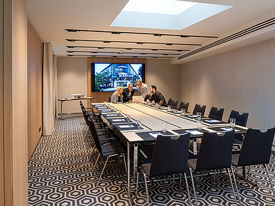 Meeting room 2 with conference table, modern technology, screen and a professional meeting atmosphere.