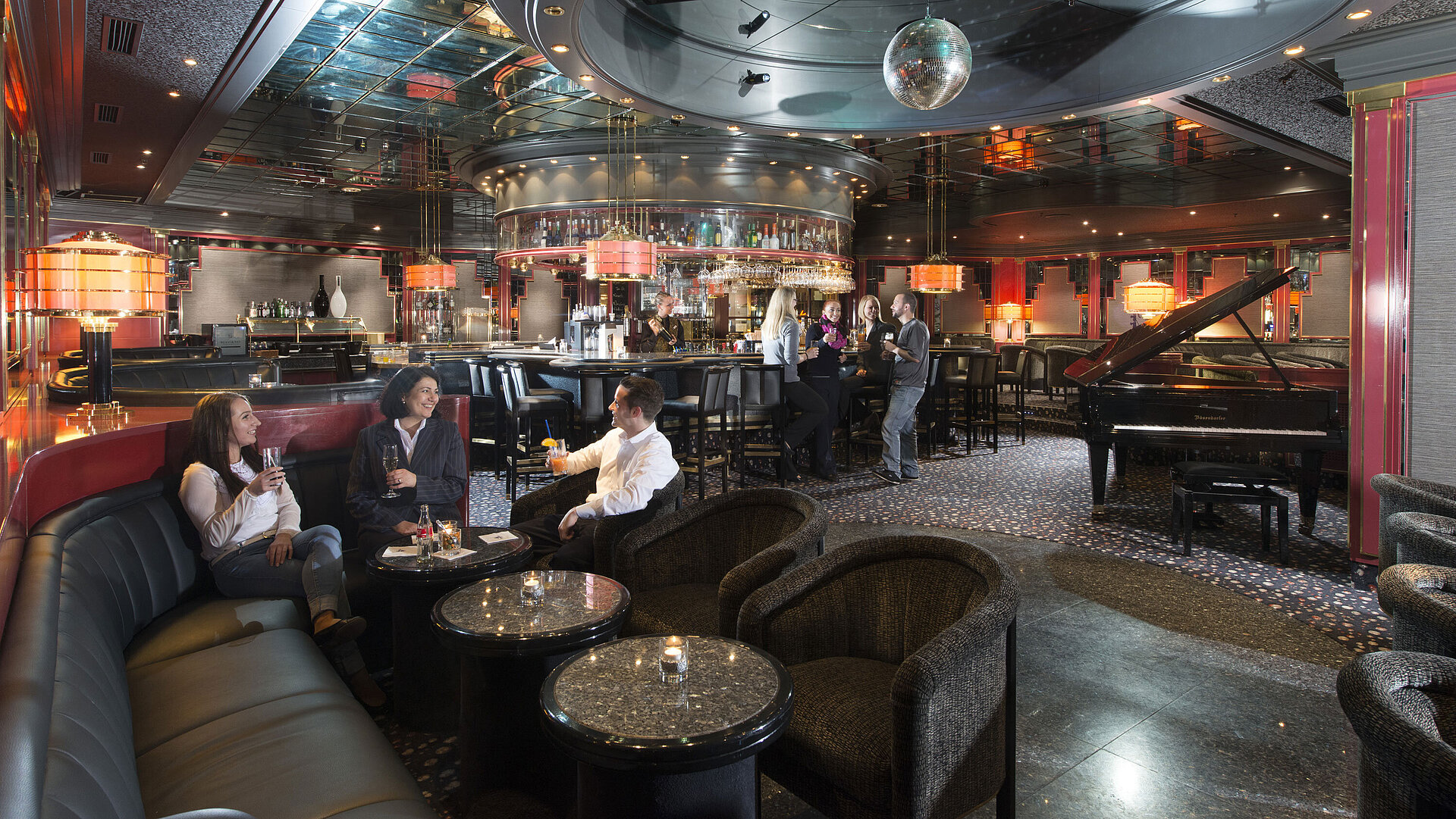Guests enjoy cocktails in the stylish bar with a piano and elegant lighting at Maritim Hotel Hannover.