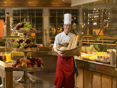 Boulanger avec panier de pain au buffet du petit déjeuner du Maritim Hotel Stuttgart, fruits frais autour