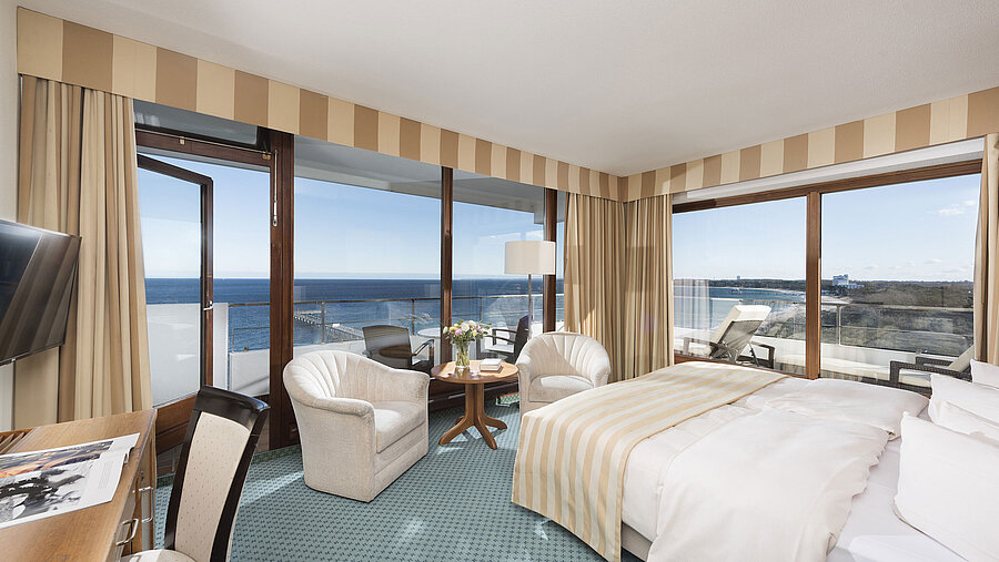 Camera superior al Maritim Seehotel Timmendorfer Strand con vista mare, balcone, area relax e letto grande.