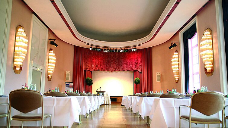 Sala conferenze al Maritim Hotel Bad Wildungen con palco, tende rosse e luce naturale