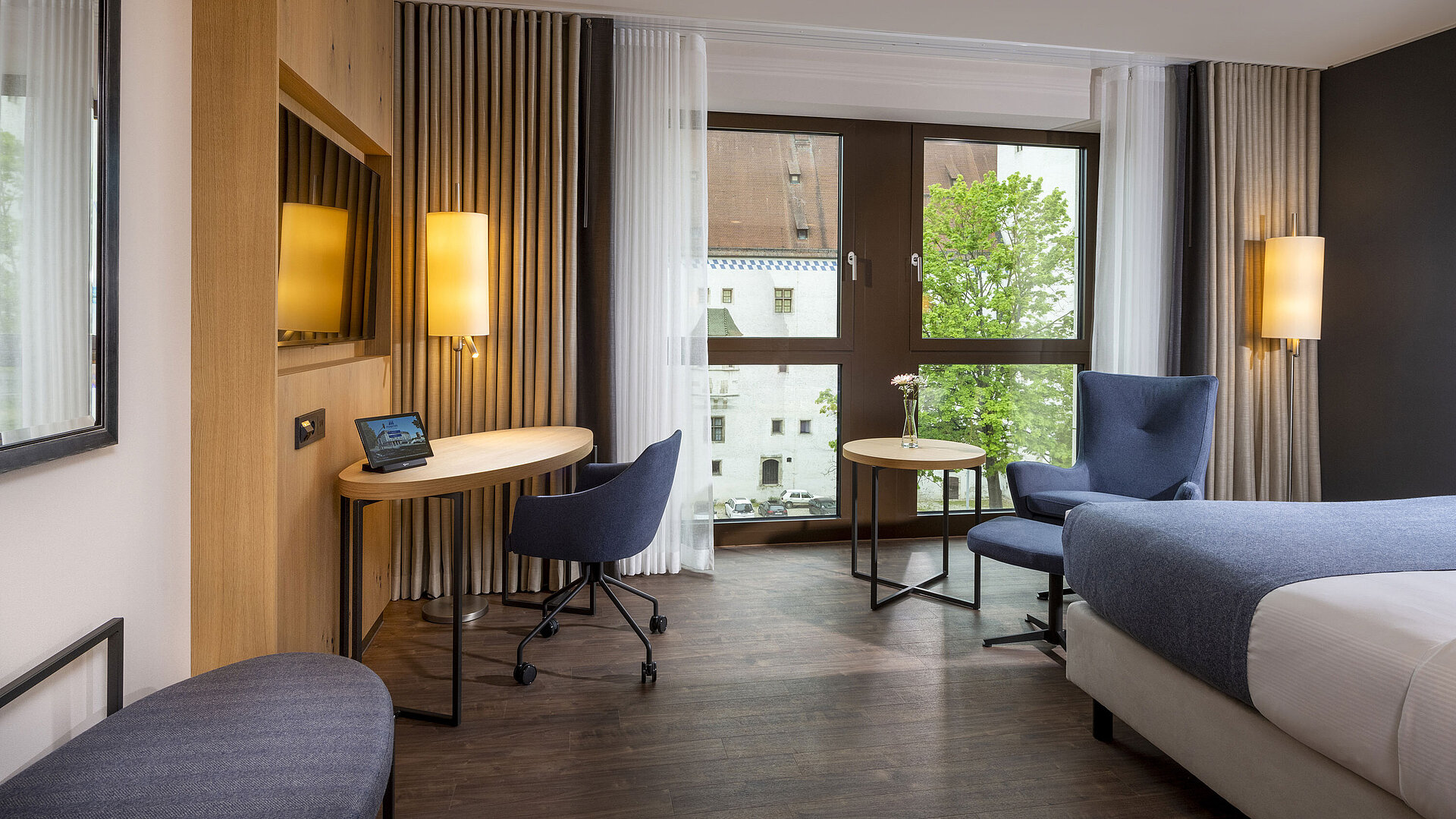 Habitación moderna del Maritim Hotel Ingolstadt con escritorio y vista a la ciudad.
