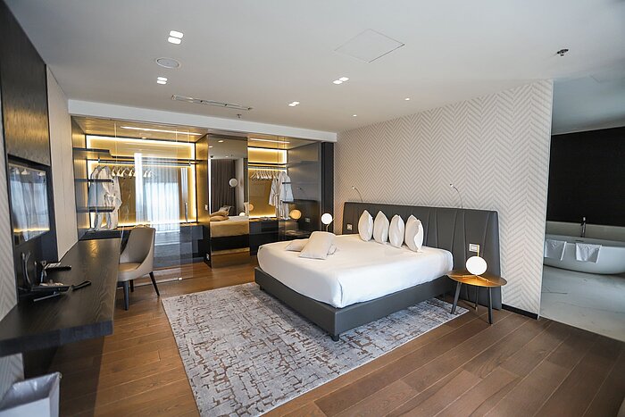 Presidential suite Designer bedroom with spacious bed, mirror wall and dressing area at Maritim Hotel Plaza Tirana