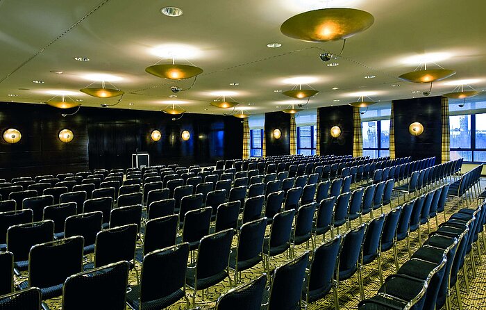 Conference room at Maritim Hotel Düsseldorf with elegant lighting and row seating, perfect for meetings and events.