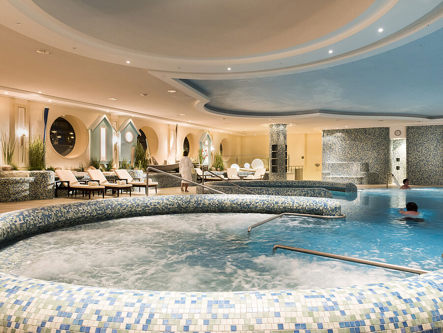 Grande piscine bien-être avec jacuzzi et chaises longues au Maritim Seehotel Timmendorfer Strand.