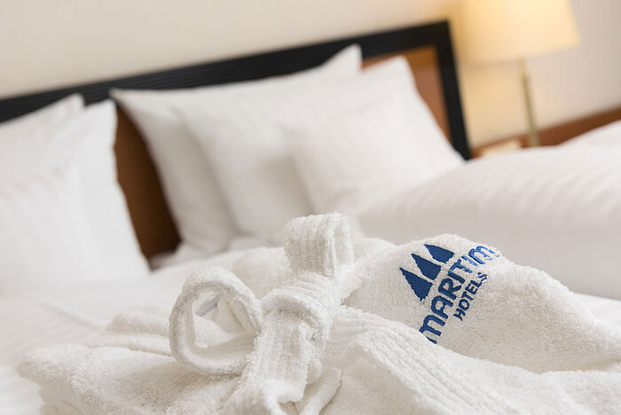 Morbido accappatoio con logo Maritim sul letto al Maritim Hotel Bad Salzuflen