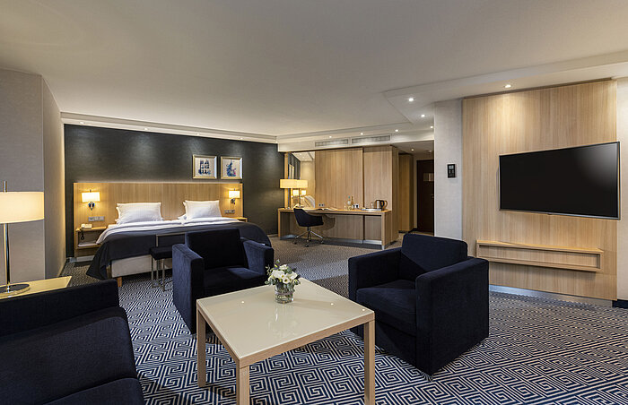 Ampia Junior Suite del Maritim Hotel Würzburg con letto matrimoniale, area salotto e design