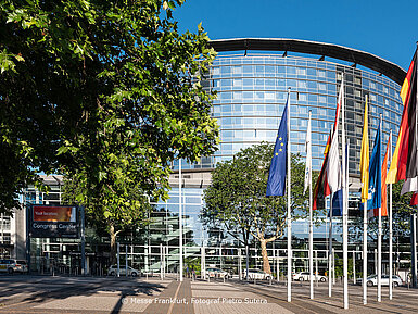 Vue extérieure du Congress Center Messe Frankfurt avec façade en verre et drapeaux.