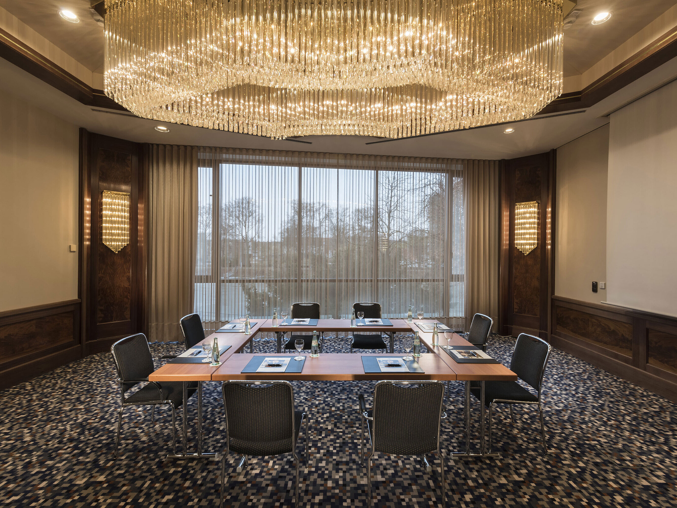 Salle de réunion élégante avec grand lustre et lumière naturelle à l’hôtel Maritim Ulm.