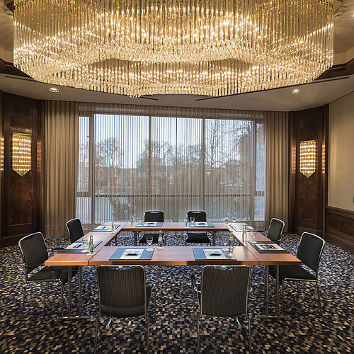 Salle de réunion élégante avec grand lustre et lumière naturelle à l’hôtel Maritim Ulm.