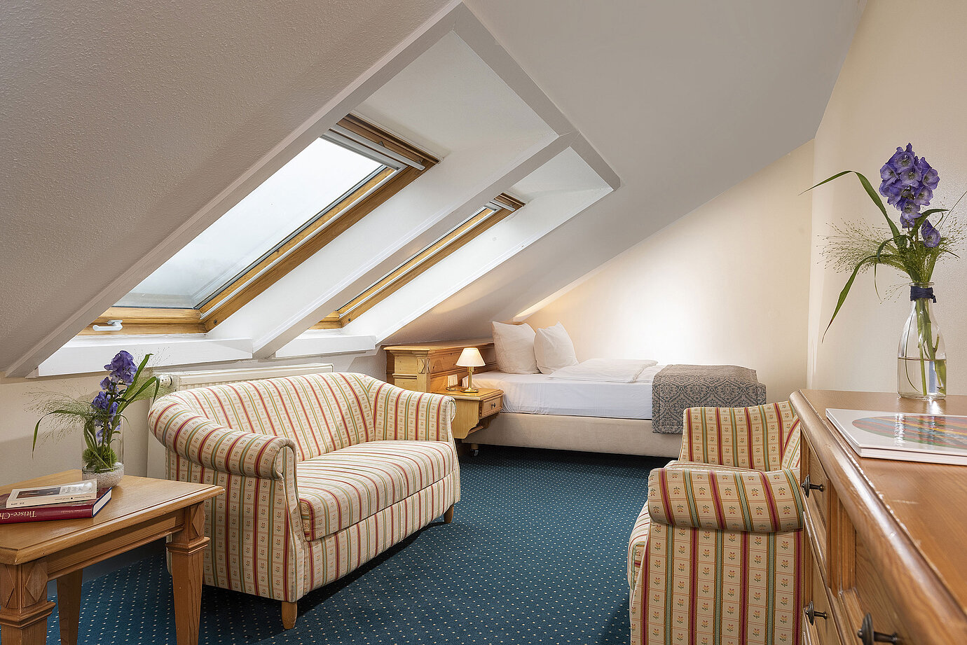 Cosy attic room with skylights, sofa and armchair at Maritim Hotel Titisee