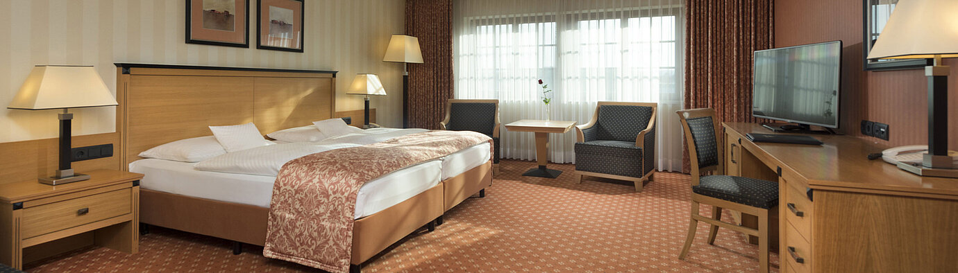 Camera classic al Maritim Hotel Dresden con letto matrimoniale, area salotto e arredamento classico.