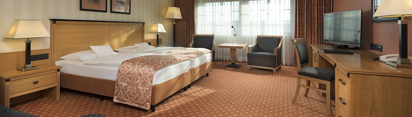 Camera classic al Maritim Hotel Dresden con letto matrimoniale, area salotto e arredamento classico.