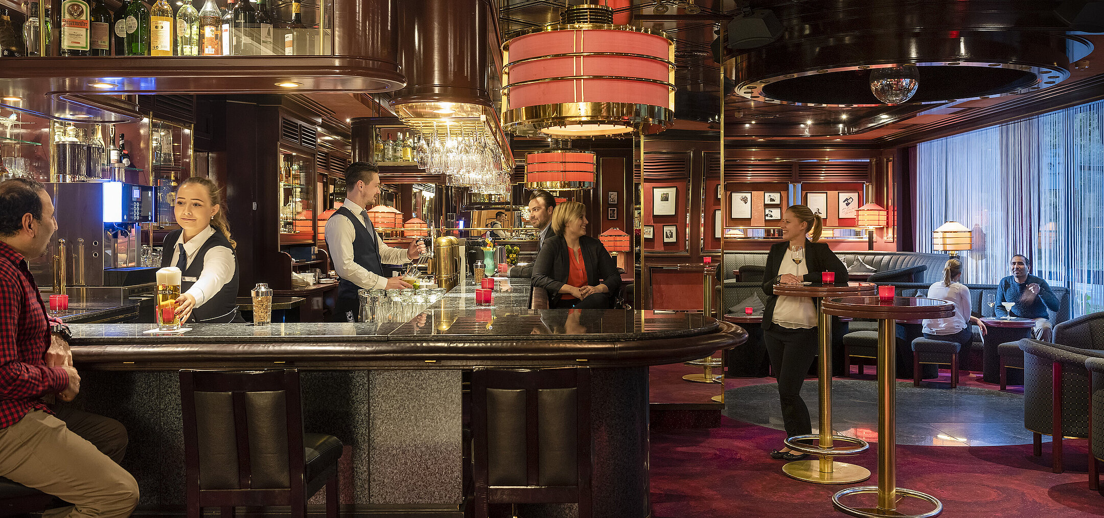  Les clients profitent de boissons et de l'atmosphère détendue dans la bar élégant de l'hôtel Maritim Bremen.
