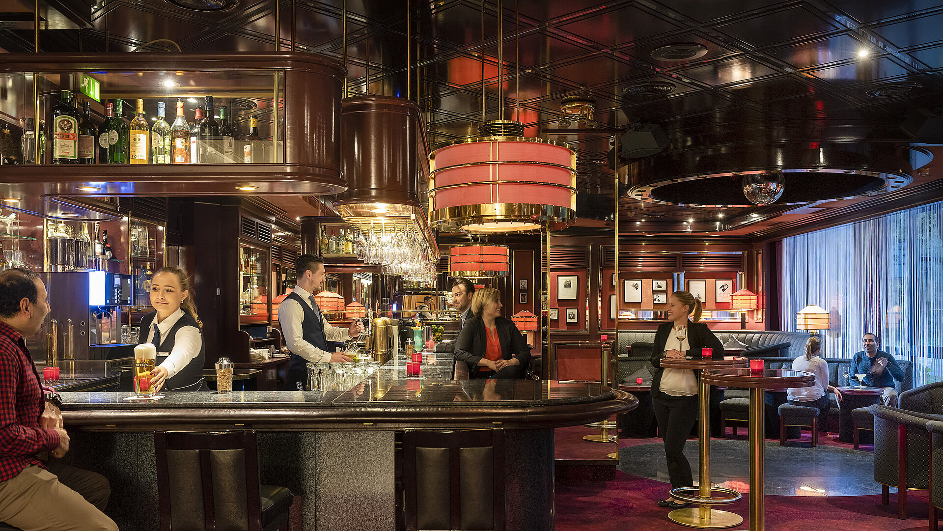 Guests enjoy drinks and a relaxed atmosphere in the stylish bar of Maritim Hotel Bremen, served by friendly staff.